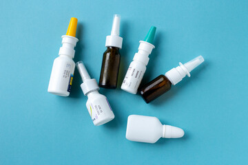 Bottles of nasal spray on blue background, medicine flat lay, treatment for colds