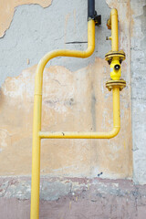 
Yellow gas pipe on the background of the old wall, old destroyed architecture, environmental friendliness concept