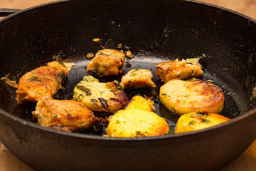 fried potatoes with fish in a pan