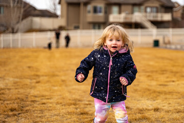 Fototapeta premium Toddler running and playing in winter