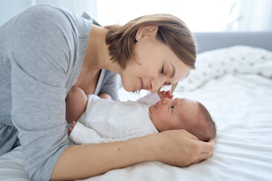 Pretty baby boy on mother hands in room closeup. Motherhood. Childhood. . High quality photo