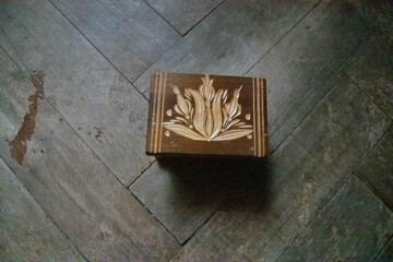 Handmade box with carved models on a wood background.