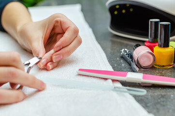 Woman cutting nails with nail clippers - close-up. Home nail care