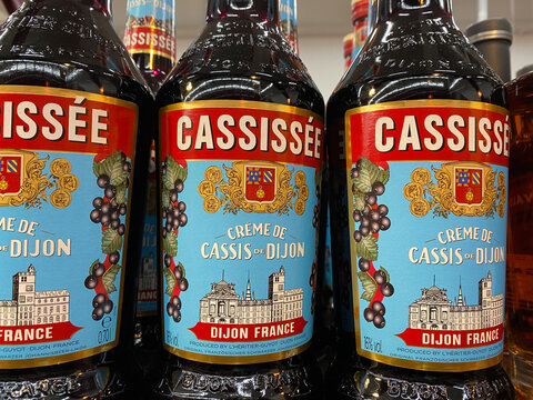Viersen, Germany - January 9. 2021: Closeup of Cassissee creme cassis de dijon bottles in shelf of german supermarket (focus on bottle right)