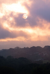 MOON OVER THE MOUNTAINS IN GOLDEN HOUR IN COSTA RICA WITH BIRDS FLYING AROUND