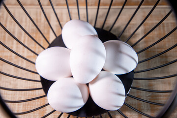 Huevos blancos en canasta de metal