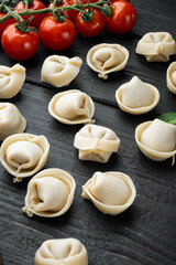 Tortellini with Parmesan and Basil, on black wooden table background