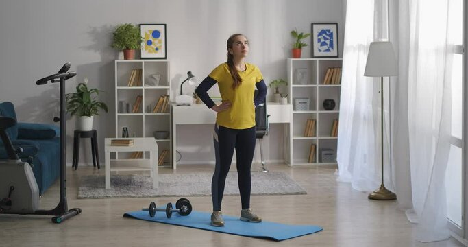 young woman is doing gymnastics for spinal, moving head to sides, preventing of osteochondrosis