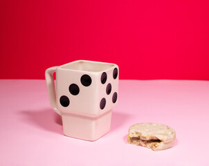 Taza lúdica dado desayuno sobre fondo rojo y rosa