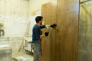 Smiling man standing in the paint booth of the workshop