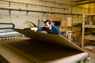 Fototapeta na wymiar Hispanic man working on the construction of plywood furniture