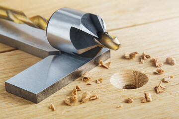 Countersink drill bit with steel triangle ruler make sink in hole for screw in wooden oak plank