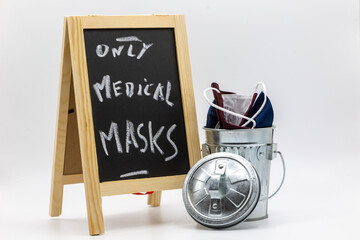 Chalkboard with the inscription only medical masks with silver garbage can and masks in Covid-19 times