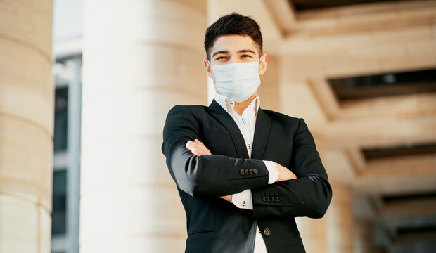 businessman and coronavirus. put a protective mask on his face against the virus, bacteria, germs, infections and flu. He's standing there in a black business suit. copy space