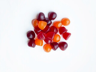Group of red, orange and purple multivitamin gummies isolated on white background. Healthy lifestyle concept..