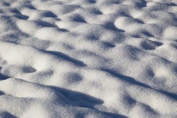 Fresh white snow sparkling in the sun with highlights and shadows for background