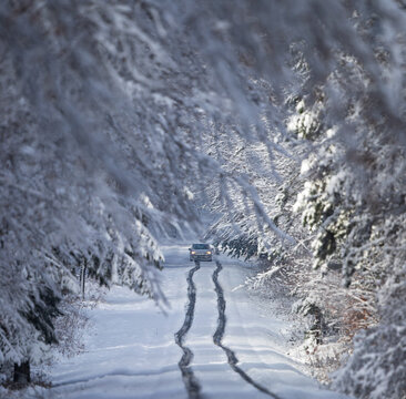 Car driving on snowy winter road in forest, Badem-Wuerttemberg, Germany