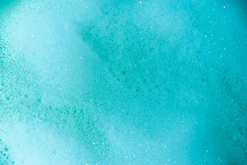 water foam and bubbles of blue color as background. cosmetology concept
