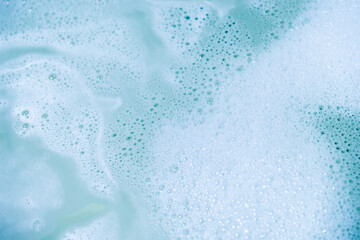 water foam and bubbles of blue color as background. cosmetology concept