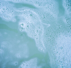 water foam and bubbles of blue color as background. cosmetology concept