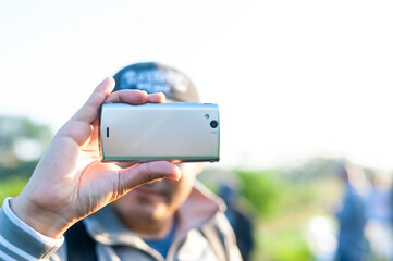 Man recording with his cellphone in the field in the morning