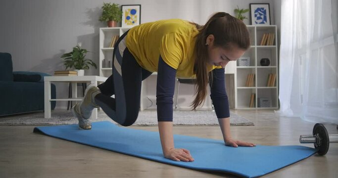 home fitness during self-isolation and lockdown, woman is training on floor of living room, keeping fit