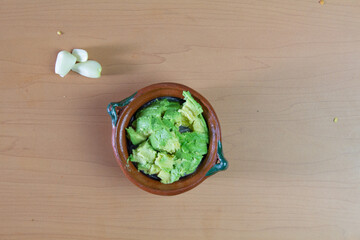 top view of avocado guacamole in clay bowl. Mexican food, avocado dip
