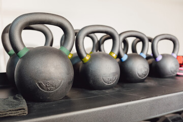 Fototapeta na wymiar Kettlebells on rack for strength training in gym.
