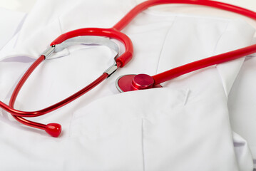Red stethoscope on white background, close up