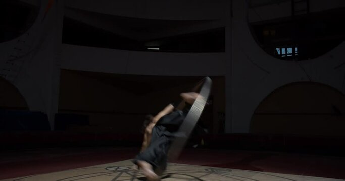 Athletic training session, young circus performer is spinning in a wheel, 4k