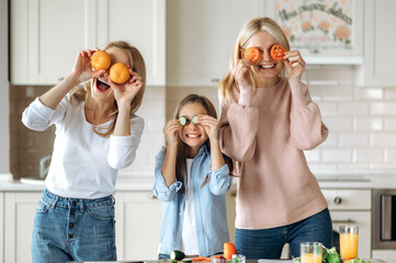 Three female generation spend time together at the kitchen at home. Caucasian happy grandma...