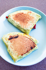 plant-based food, vegan version fo the viral layered tortilla wrap hack with red peppers grated dairy-free cheese avocado and refried beans