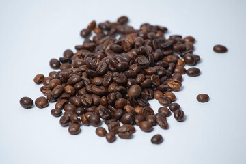 Roasted coffee beans scattered on a white surface