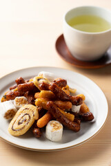 Various kinds of karinto and green tea placed on a wooden background