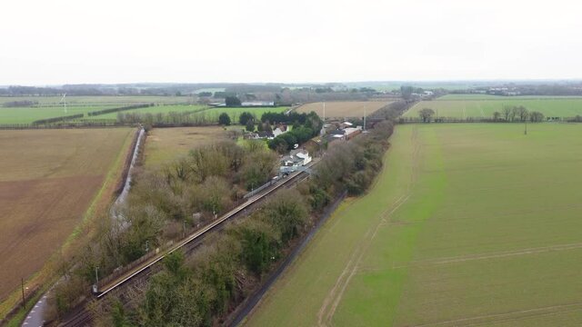 A drone reveal shot of a village train station in Kent, England. Adisham train station.