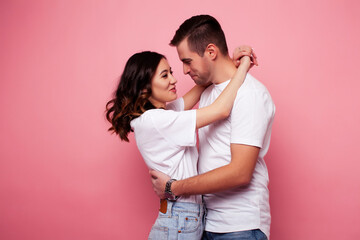 Fototapeta premium young cheerful caucasian couple together having fun on pink background, guy ang girl modern relationship, lifestyle people concept