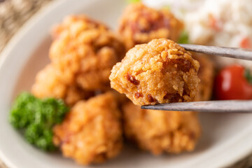 箸で挟んだ唐揚げのアップの写真