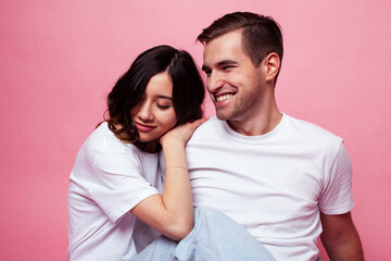 Fototapeta premium young cheerful caucasian couple together having fun on pink background, guy ang girl modern relationship, lifestyle people concept