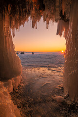 Beautiful sunset over lake Baikal look through the ice cave. The water in Lake Baikal freezes in bizarre shapes to spectacular landscape in winter season.