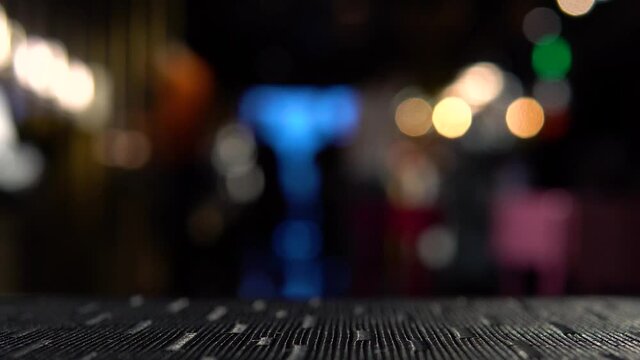 top of the table against a background of beautiful multi-colored lights. people walk around the restaurant.