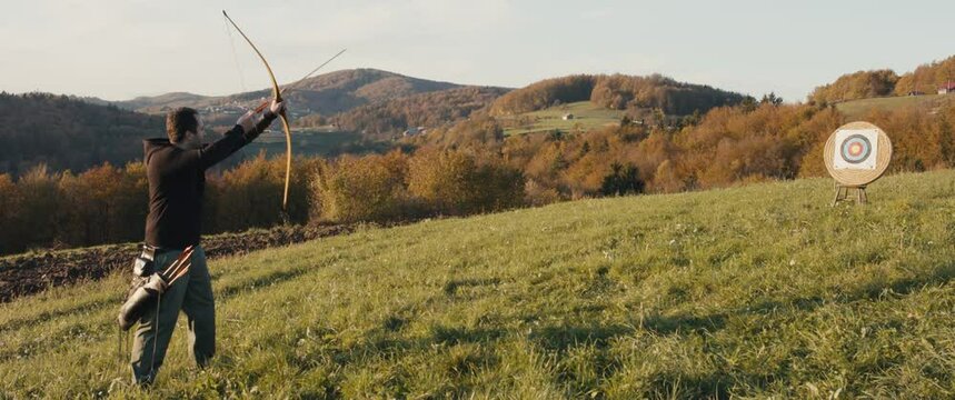 Archer man aim a bow release arrow in target outdoors nature sport