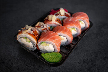 Traditional Japanese rolls with salmon and smoked eel in box