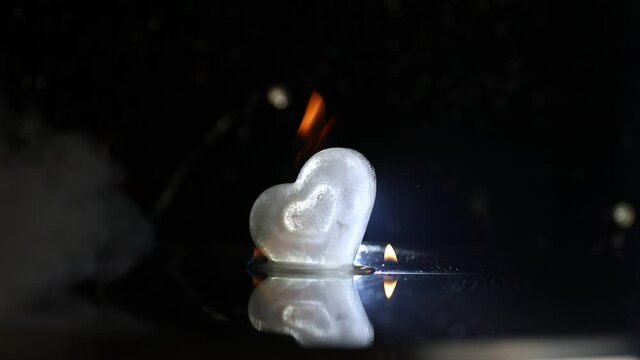 Valentines background. Valentine's Day heart on a dark wooden table. Burning ice hearts. Heart in fire. Dark toned foggy background. Selective focus