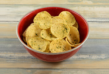Dutch rosemary hummus chips in red snack bowl on table
