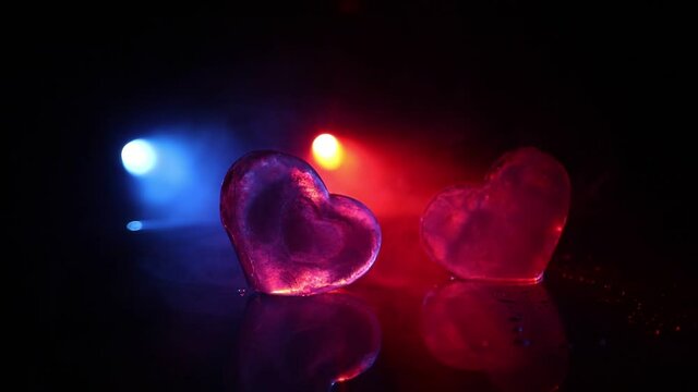 Valentines background. Valentine's Day heart on a dark wooden table. Burning ice hearts. Heart in fire. Dark toned foggy background. Selective focus