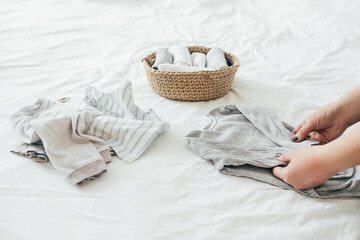 Woman folding clothes in jute basket in the konmari system. Concept of organizing minimalism clothes