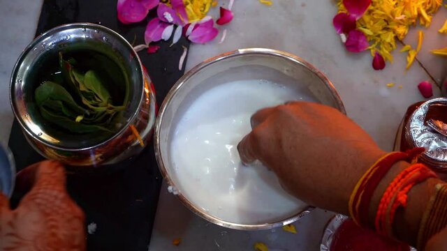 Women Washing Silver Coin With Milk, Honey, And Curd Before Offering To Goddess Lakshmi During Diwali Pooja Celebration In India. - Topdown Shot