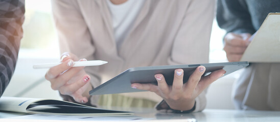 Young female financial inspector working on laptop computer and checking document.