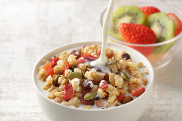 ミルクを注いでいる朝食のシリアルやフレーク