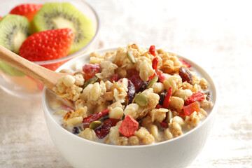ミルクを注いだ朝食のシリアルやフレークと果物